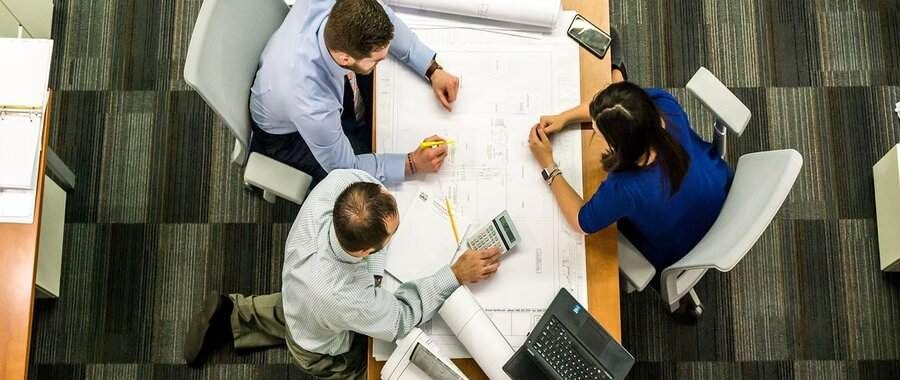 Réunion de travail autour de plans d'architecte